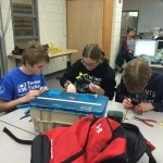 Matt, Heather & Gabrielle work on more PWM cables.  So far their recycling efforts have saved the team $168!